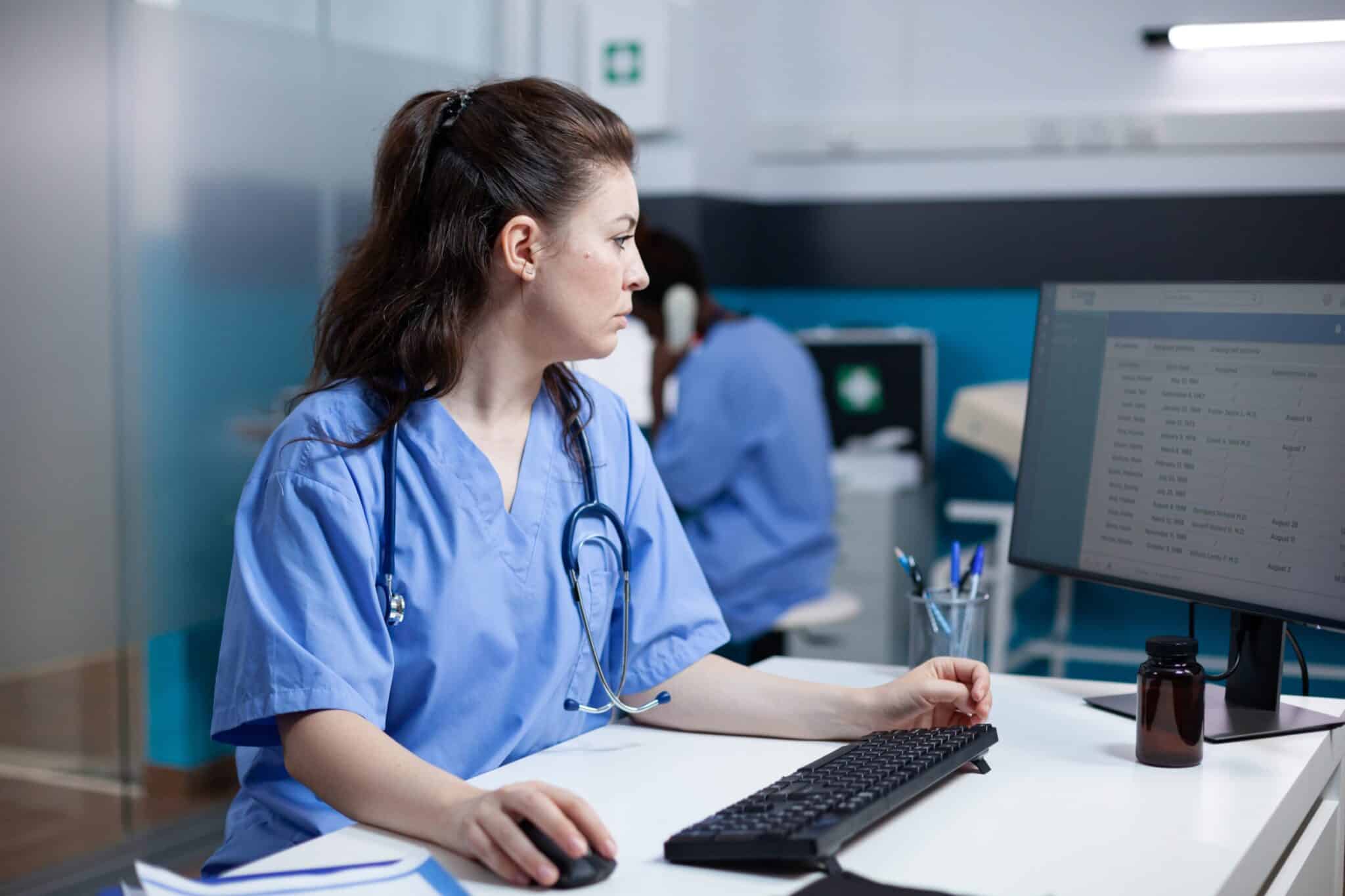 A nurse checking information on a computer monitor.