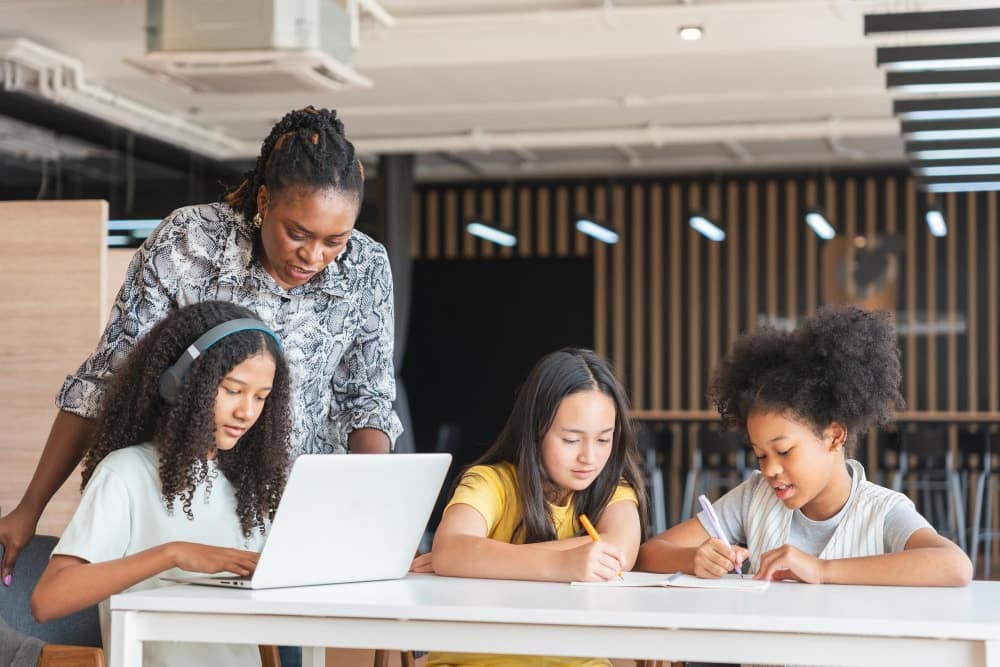 A group of students learning with teacher in modern classroom.