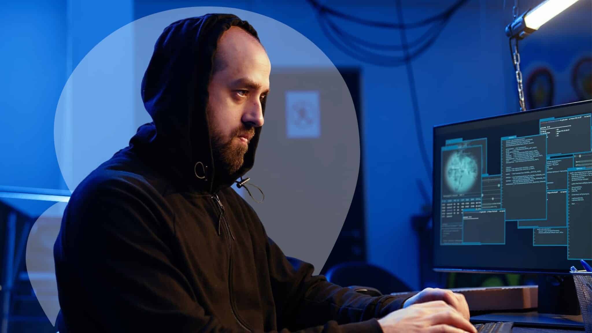 Man in a hoodie using a desktop in a dark room, symbolizing organizations’ cybersecurity readiness and the role of security teams.